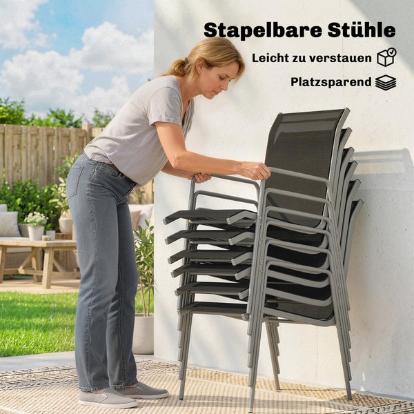 Eine Frau stapelt Gartenstühle mit Metallgestell und Textilbespannung auf einer hellen Terrasse. Platzsparende und leicht zu verstauende Stapelstühle.