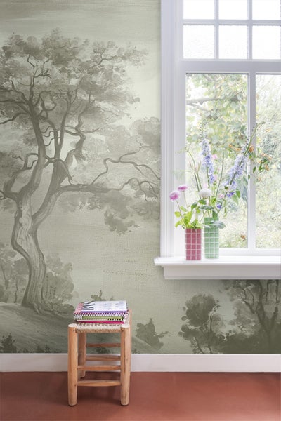Raum mit Tapete mit Baum- und Landschaftsmotiv, Fenster und Hocker mit Büchern