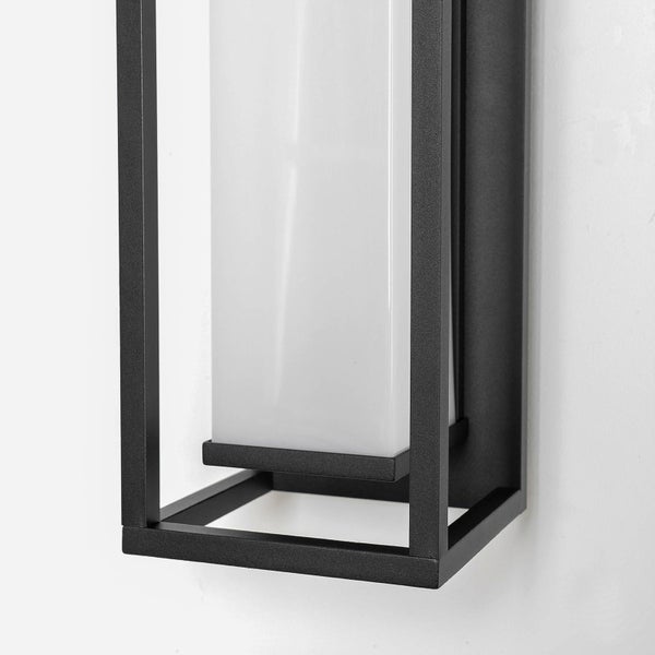 Nahaufnahme einer modernen Außenwandleuchte mit schwarzem Metallgehäuse und weißem rechteckigem Schirm.