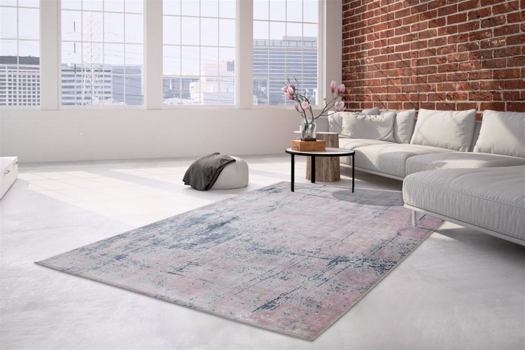 Moderner Wohnbereich mit einem rechteckigen Teppich mit abstraktem Muster in einem hellen, offen gestalteten Loft mit Backsteinwand.