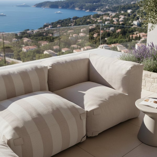 Moderner Outdoor-Lounge-Sessel aus beigem Stoff auf einer Terrasse neben einem Swimmingpool.