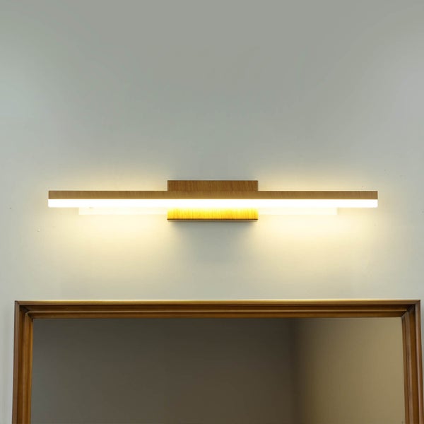 Wandleuchte aus Holz über einem Spiegel