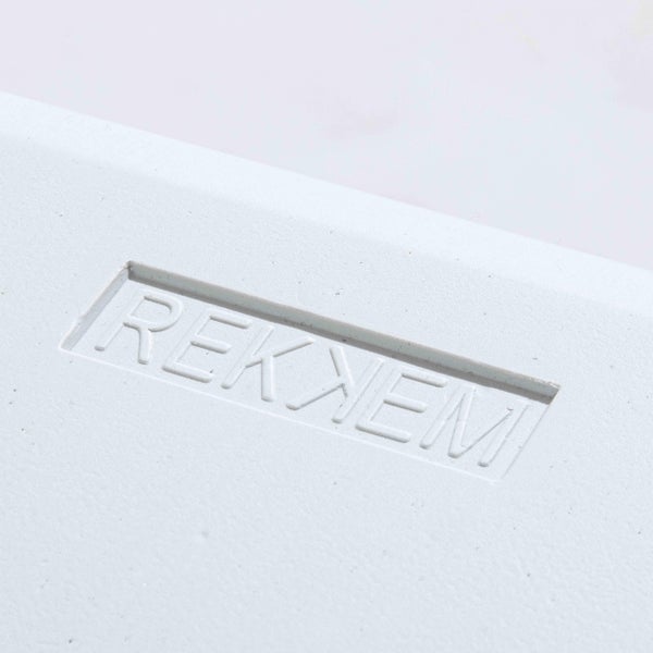 REKNEM Logo eingeprägt auf einer hellen Oberfläche.