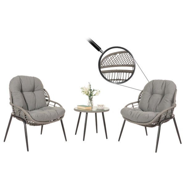 Gartenset mit zwei Sesseln, einem Tisch, Geflecht und Kissen