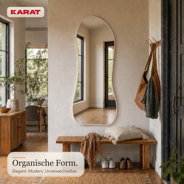 Flur mit Karat Wandspiegel in organischer Form, Holzbank mit Kissen und Textilien, helle Inneneinrichtung.