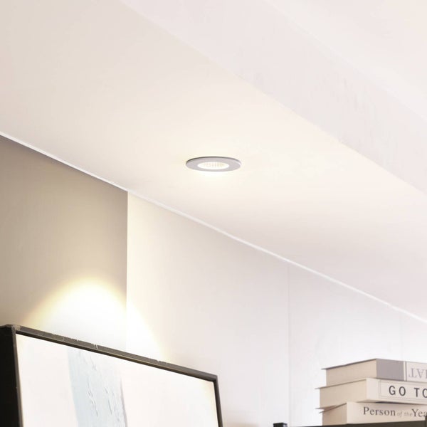 LED Einbaustrahler in einer Decke über einem Wandbild und einem Regal mit Büchern.