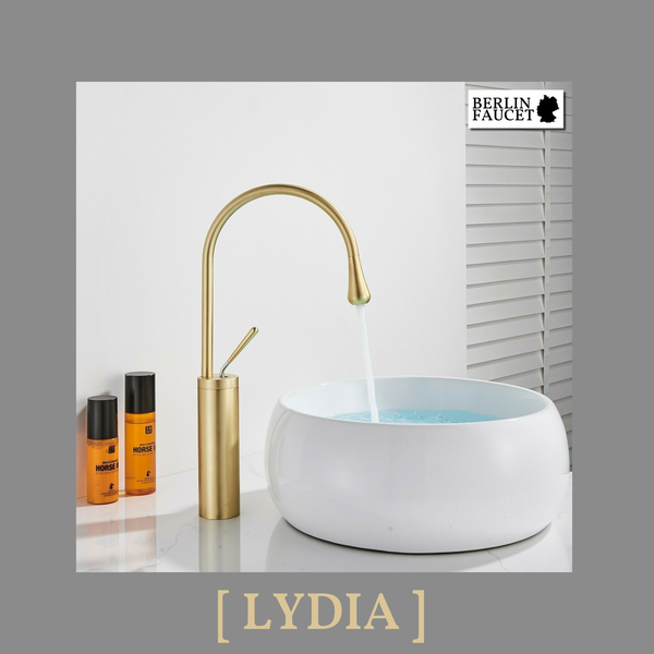 Moderne hohe Waschtischarmatur in Goldoptik mit rundem Aufsatzwaschbecken und Berlin Faucet Logo auf einem Waschtisch mit Pflegeprodukten.