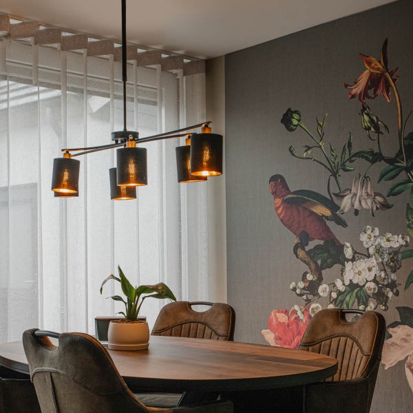 Esszimmer mit Esstisch, Stühlen, Hängelampe und dekorativer Tapete