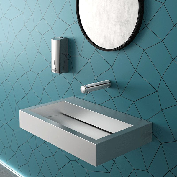 Modernes Badezimmer, rechteckiges Edelstahl-Waschbecken, Wandarmatur, Seifenspender und runder Spiegel auf Wand mit geometrischem Muster.