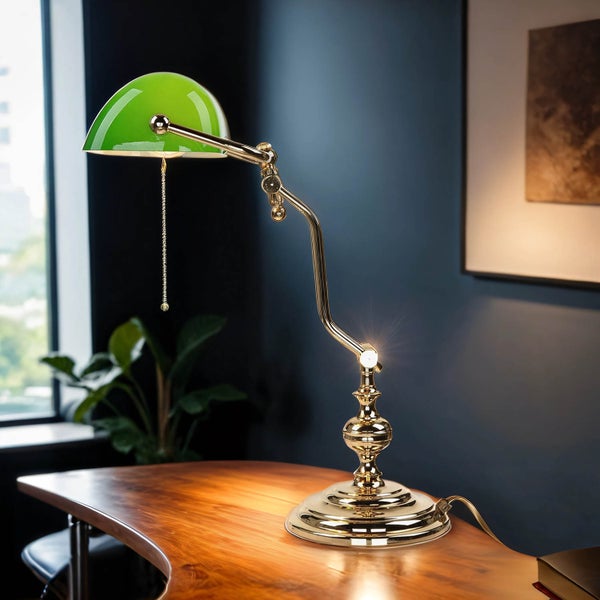 Tischleuchte mit grünem Lampenschirm und goldenem Gestell auf einem Schreibtisch