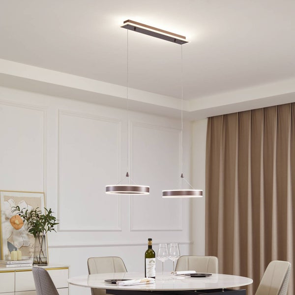 Zweiflammige LED-Pendelleuchte mit ringförmigen Schirmen über einem Esstisch in einem hellen, modern eingerichteten Raum.