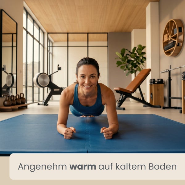 Eine Frau trainiert im Unterarmstütz auf einer blauen Puzzlematte in einem modernen Heimfitnessstudio mit Sportgeräten.