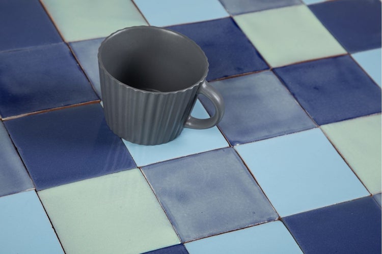 Muster aus quadratischen Fliesen und Tasse