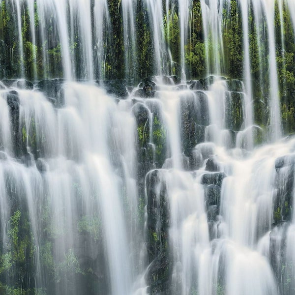 Detailaufnahme eines Wasserfalls mit fließendem Wasser über Felsen