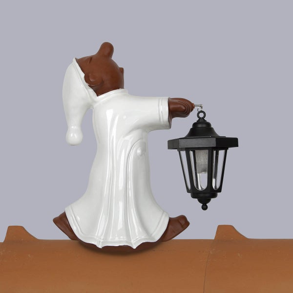 Dachfigur Schlafwandler aus Keramik mit weißem Nachthemd und schwarzer Laterne auf einem Dachziegel sitzend.