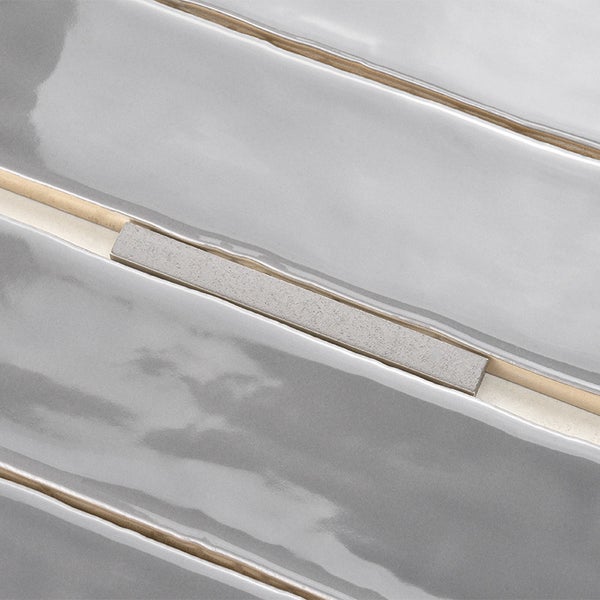 Wandfliese mit glänzender, gewellter Oberfläche und integriertem metallischem Dekorelement für moderne Wandgestaltung