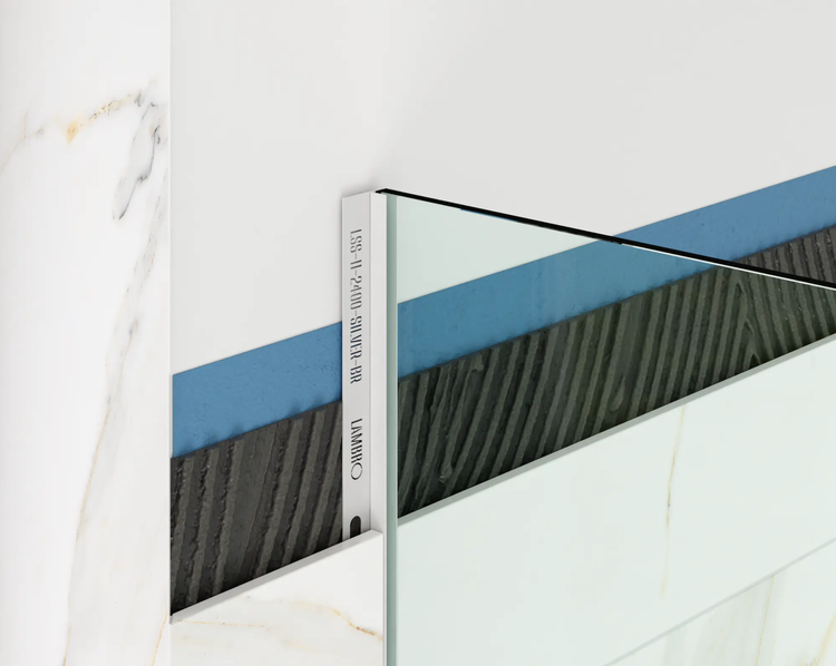 Lambro Fliesen-Abschlussprofil in Silber an einer Wand mit Marmoroptik-Fliesen, Fliesenkleber und Abdichtungsschicht.