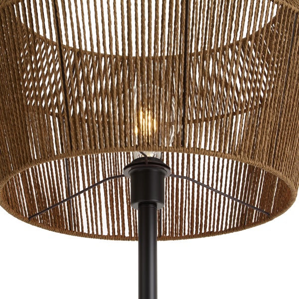 Detailansicht einer Lampe mit einem Schirm aus geflochtenem Seil und einer leuchtenden Filament-Glühbirne auf einem Metallstativ.