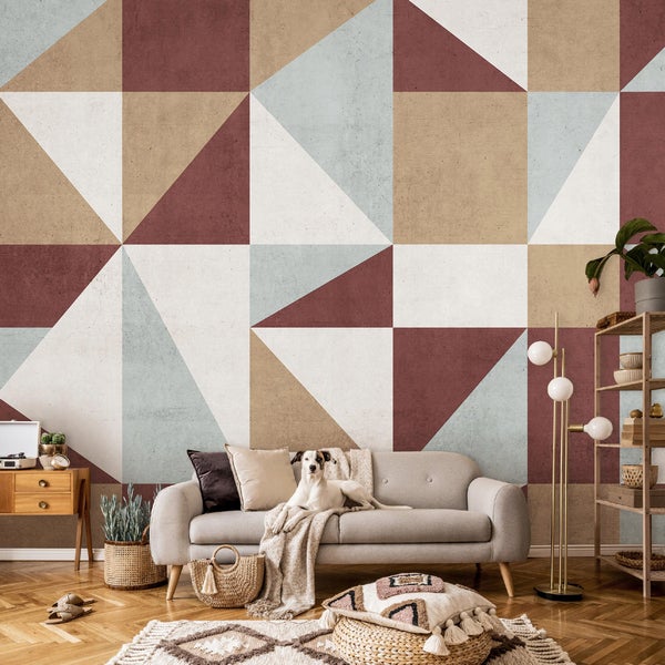 Wohnzimmer mit Sofa, Teppich, geometrischer Tapete und dekorativen Elementen für eine gemütliche Atmosphäre