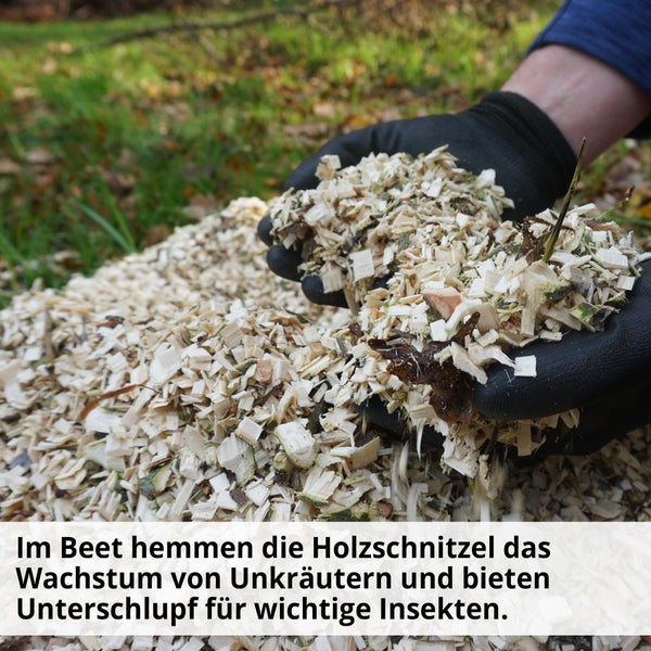 Holzhackschnitzel in Händen mit Gartenhandschuhen