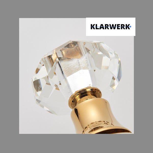 Möbelknopf in Kristalloptik mit goldfarbenem Sockel von Klarwerk Logo.