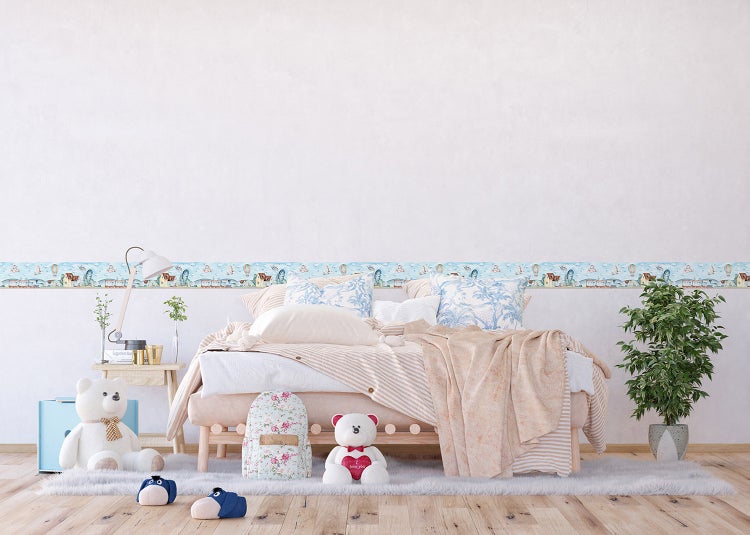 Wandbordüre für Kinderzimmer mit Landschaftsmotiv in einem hellen, freundlich gestalteten Schlafzimmer mit Bett und Spielzeug.