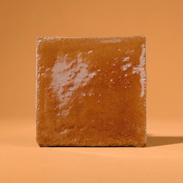 Quadratische, glasierte Wandfliese mit unebener Oberfläche.