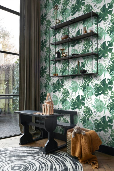 Wohnraum mit Blättertapete, Regal und dunklem Holztisch