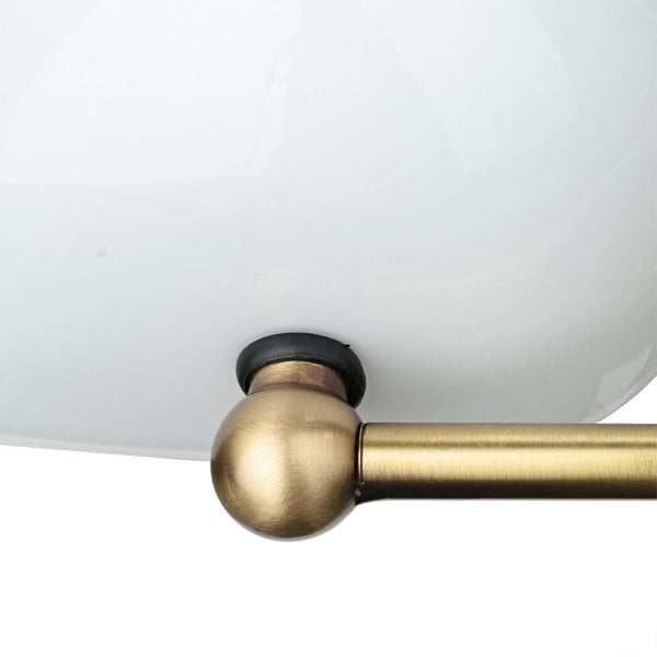 Detailansicht einer Lampe mit weißem Schirm und goldenem Arm