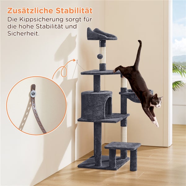 Grauer Kratzbaum mit Kippsicherung an der Wand und springender Katze.