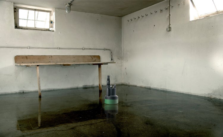 Überfluteter Kellerraum mit Tauchpumpe im Wasser