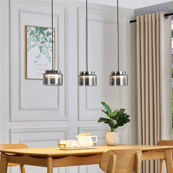 Dreiflammige Pendelleuchte mit Glasschirmen über einem hellen Holztisch im modernen Esszimmer mit Wandleisten.