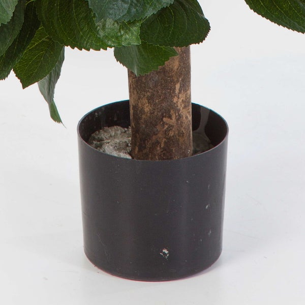 Künstliche Pflanze im schwarzen Kunststofftopf mit strukturiertem Stamm und grünen Blättern.