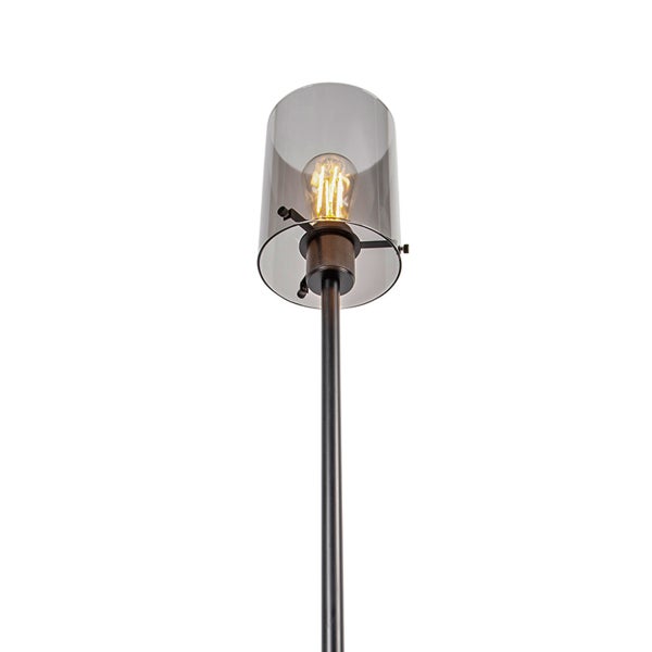 Stehleuchte mit zylindrischem Schirm aus Rauchglas und leuchtendem Filament-Leuchtmittel an einem schwarzen Metallstab.