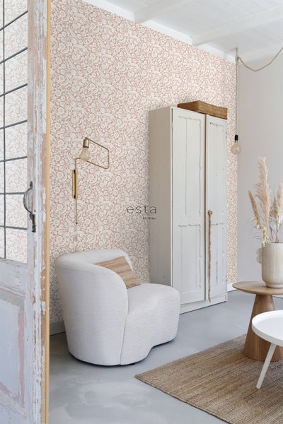 Wohnraum mit geblümter Tapete, Sessel und Holzschrank