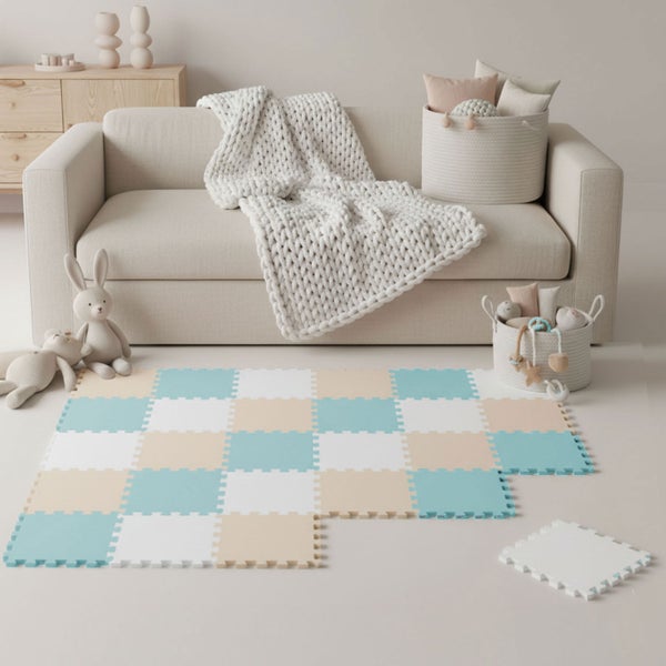 Spielmatte aus Schaumstoff-Puzzleteilen in Blau, Beige und Weiß vor einem Sofa in einem hellen, aufgeräumten Kinderzimmer.