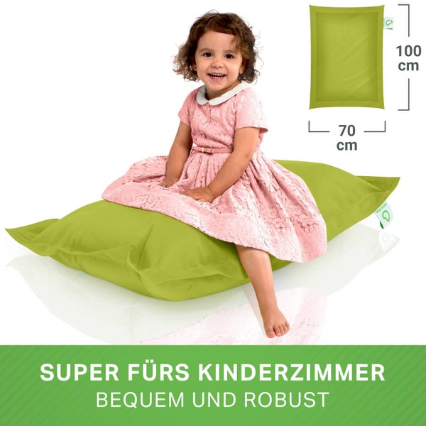 Ein Kinderzimmer mit einem Babybett aus Rattan, einem Hocker und einer Girlande