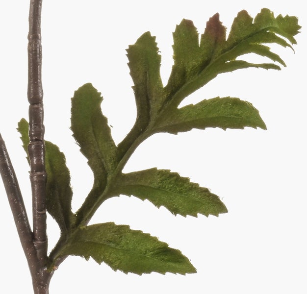 Künstliche Magnolienblüte in Dunkelrosa aus Textilmaterial an einem braunen Zweig.