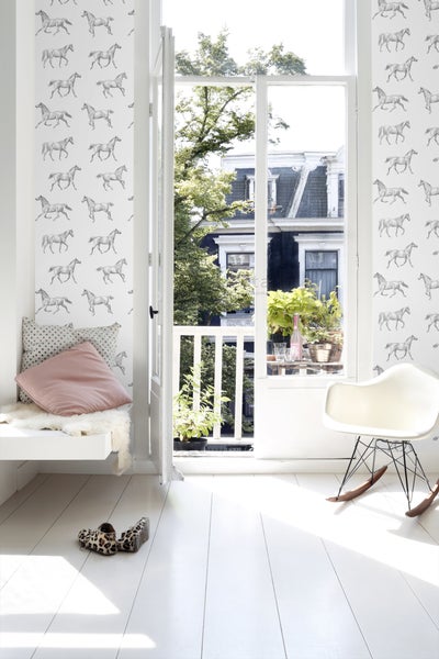 Heller Raum mit Pferdetapete, Sitzbank am Fenster und Blick auf einen Balkon