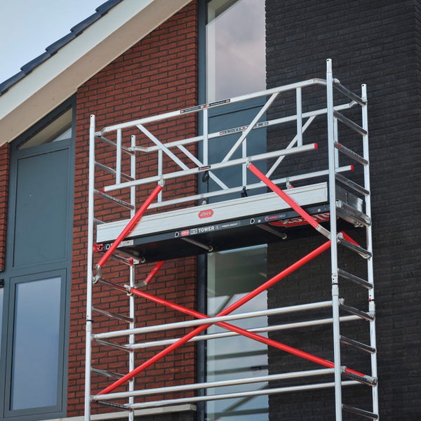 Aluminium Rollgerüst vor einem Backsteingebäude