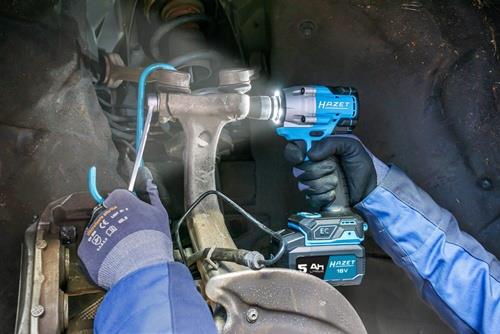 Eine Person arbeitet mit einem Hazet Akku-Schlagschrauber an einem Fahrzeug.