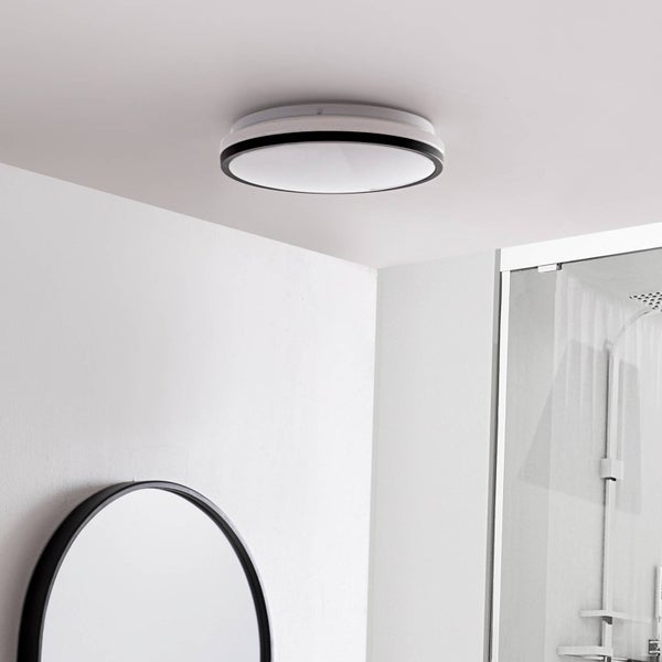 Moderne, runde LED-Deckenleuchte mit schwarzem Rand in einem hellen Badezimmer mit Spiegel und Dusche.