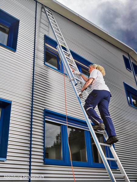 Frau steigt auf einer Aluminium-Mehrzweckleiter an einer Fassade hoch