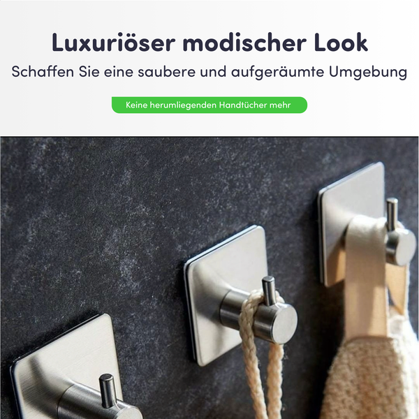 Selbstklebende Handtuchhaken aus gebürstetem Metall an einer strukturierten Wand für eine organisierte Umgebung.