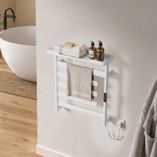 Elektrischer Handtuchheizkörper mit Ablagefläche an einer Wand montiert, inklusive Handtücher und Seifenspender in einem modernen Badezimmer.
