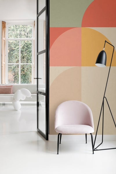 Raumansicht mit geometrischer Tapete, Sessel und Stehlampe