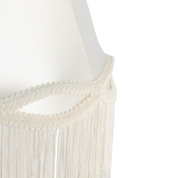 Detailaufnahme eines Lampenschirms aus Textil mit dekorativer Borte und Fransen.