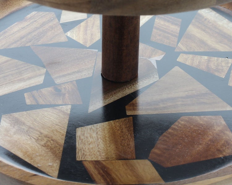 Detailaufnahme eines Holztabletts mit Mosaikmuster aus unregelmäßigen Holzstücken und einer zentralen Holzsäule.