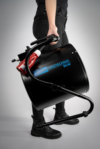 Person trägt Elektroheizer mit 9 Kilowatt Leistung