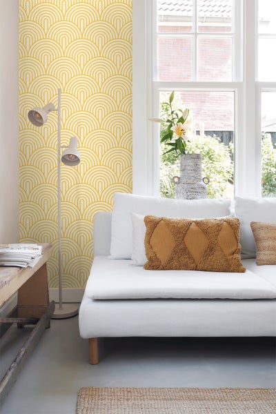 Helles Wohnzimmer mit Couch, Stehlampe und Tapete mit Bogenmuster
